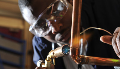 Student welding a pipe